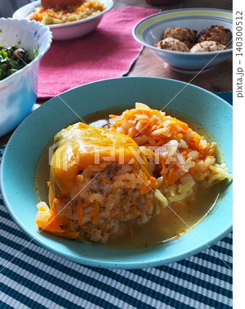 Cabbage rolls filled with meat and grains sit in a blue bowl. The dish is covered in a rich tomato sauce. It is ready to be enjoyed at dinner time in a warm kitchen Cabbage rolls filled with meat and grains sit in a blue bowl. The dish is covered in a rich tomato sauce. It is ready to be enjoyed at dinner time in a warm kitchen 140300512