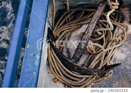 Metal anchor lying on board boat sailing on lake, sea vacation on ship Metal anchor lying on board boat sailing on lake, sea vacation on ship 140301520