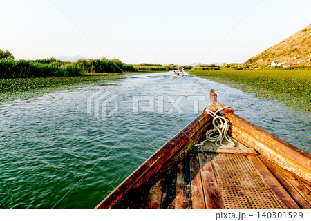Wooden boat yacht sailing on water Skadar Lake in Montenegro, summer landscape 140301529