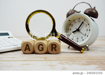 AGR Adjusted Gross Revenue alphabet letters with magnifying glass, calculator and alarm clock 140301550