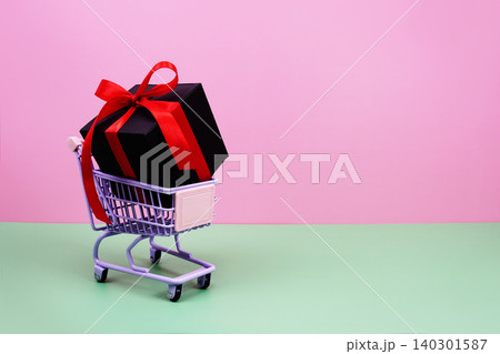 Shopping Cart and Gift Box on pink background with copy space Shopping Cart and Gift Box on pink background with copy space 140301587
