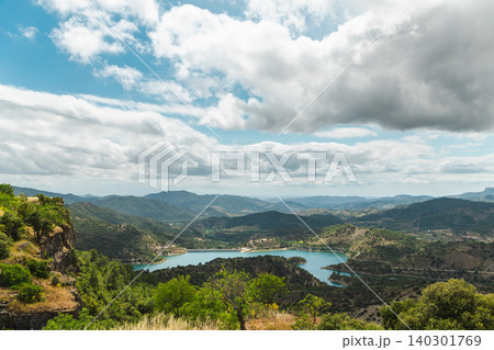 Mountain panorama with turquoise reservoir surrounded by rolling hills and dramatic clouds in Catalonia, Spain Mountain panorama with turquoise reservoir surrounded by rolling hills and dramatic clouds in Catalonia, Spain 140301769