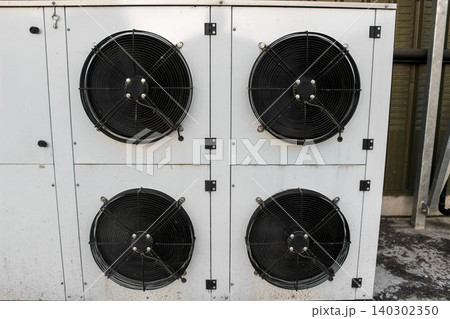 Industrial blast freezer evaporator unit featuring four high-powered black axial fans mounted on a durable white metal casing, designed for rapid large-scale refrigeration and cooling. Industrial blast freezer evaporator unit featuring four high-powered black axial fans mounted on a durable white metal casing, designed for rapid large-scale refrigeration and cooling. 140302350