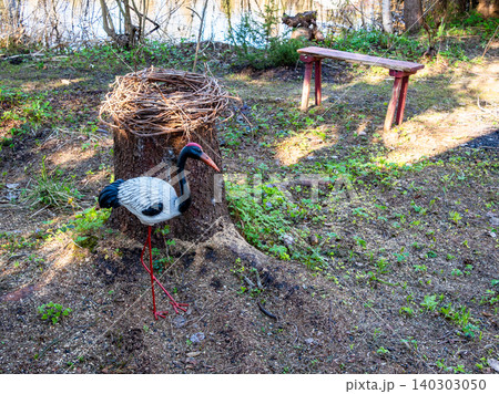 handmade stork figure near nest made on tree stump 140303050