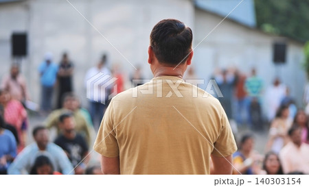 Man watching a crowd celebrating Ganesh Chaturthi festival outdoors 140303154