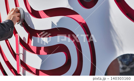 Woman's hand navigating a graphic red and white maze. Business solution concept Woman's hand navigating a graphic red and white maze. Business solution concept 140303160