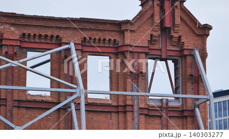 Building facade reconstruction in Moscow with scaffolding and visible brickwork Building facade reconstruction in Moscow with scaffolding and visible brickwork 140303277