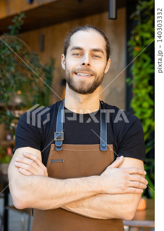 Portrait of smiling waiter with crossed arms 140303332
