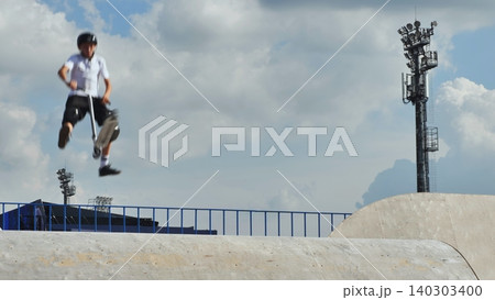 Boy performing scooter jump in skatepark, extreme sport training 140303400