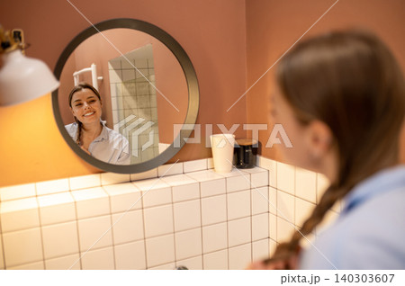 Cute young woman having morning procedures in the bathroom and looking happy 140303607