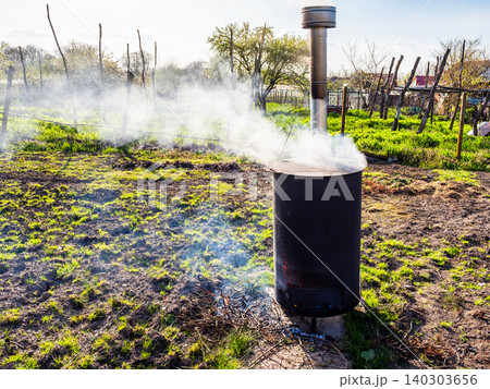 garbage burns in incinerator barrel in garden garbage burns in incinerator barrel in garden 140303656