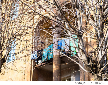 bare tree and clothes drying on balcony of house 140303760