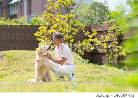 犬と遊ぶシニア男性 140304472