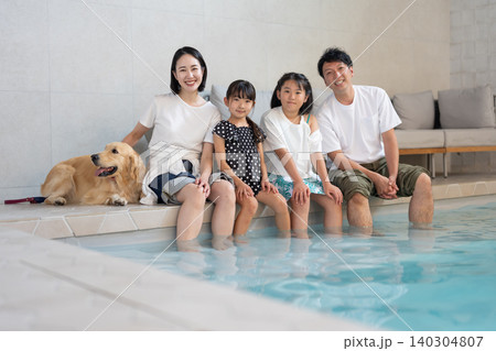 プールで犬と一緒に遊ぶ家族 プールで犬と一緒に遊ぶ家族 140304807