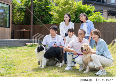 庭で犬と遊ぶ三世代家族 庭で犬と遊ぶ三世代家族 140304927