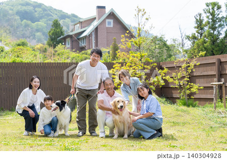 庭で犬と遊ぶ三世代家族 庭で犬と遊ぶ三世代家族 140304928