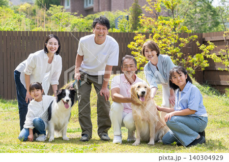庭で犬と遊ぶ三世代家族 庭で犬と遊ぶ三世代家族 140304929