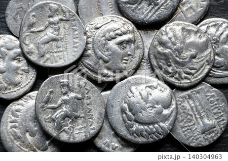 Close-up of a pile of ancient Greek coins. Macro photography of old silver money of Alexander the Great. Historical currency, wealth and archaeology concept 140304963