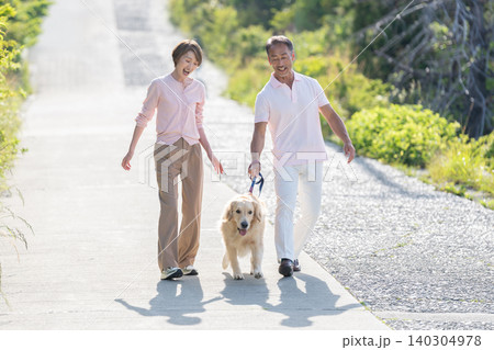 犬の散歩をするシニア夫婦 140304978