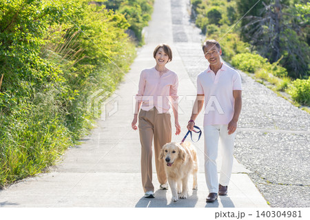 犬の散歩をするシニア夫婦 140304981