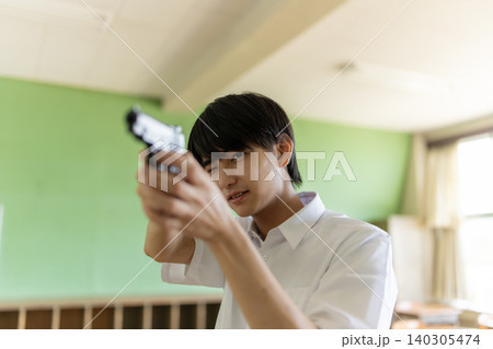 銃を構え狙いを定める少年 140305474