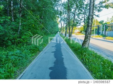 Tree-lined sidewalk beside a suburban road at sunrise Tree-lined sidewalk beside a suburban road at sunrise 140306587