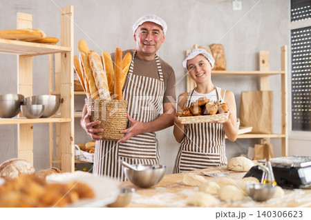 Teenage girl and male baker holding bakery products 140306623