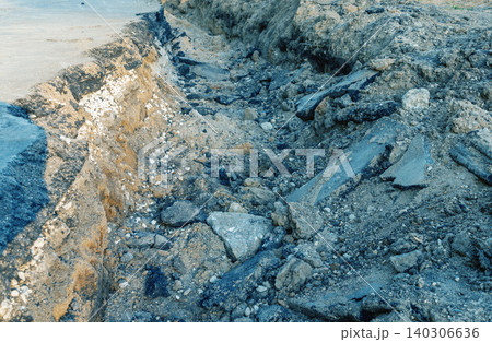Eroded coastal cliff with exposed rock and sand Eroded coastal cliff with exposed rock and sand 140306636