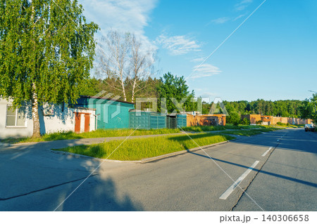 Row of colorful metal garages along a suburban roadside with trees Row of colorful metal garages along a suburban roadside with trees 140306658