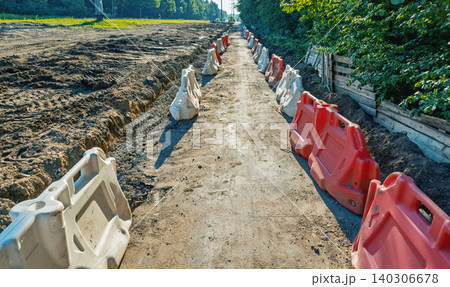 Temporary construction pathway lined with plastic traffic barriers Temporary construction pathway lined with plastic traffic barriers 140306678