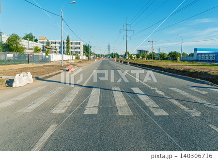 Empty urban street with worn pedestrian crosswalk under clear blue sky Empty urban street with worn pedestrian crosswalk under clear blue sky 140306716