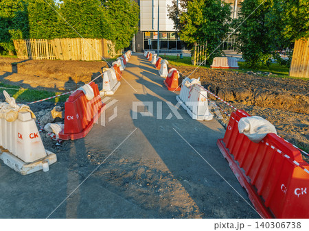 Temporary pedestrian walkway bordered by red and white safety barriers Temporary pedestrian walkway bordered by red and white safety barriers 140306738
