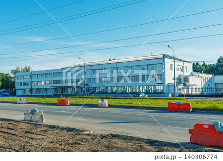 Low industrial office building by roadside with traffic barriers Low industrial office building by roadside with traffic barriers 140306774