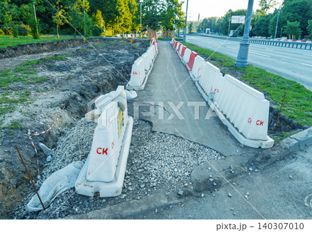 Temporary pedestrian walkway bordered by plastic barriers next to a roadside excavation Temporary pedestrian walkway bordered by plastic barriers next to a roadside excavation 140307010