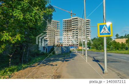 Unfinished residential high-rise buildings under construction beside suburban road Unfinished residential high-rise buildings under construction beside suburban road 140307211
