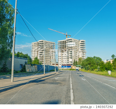 Unfinished high-rise apartment buildings under construction by roadside Unfinished high-rise apartment buildings under construction by roadside 140307292
