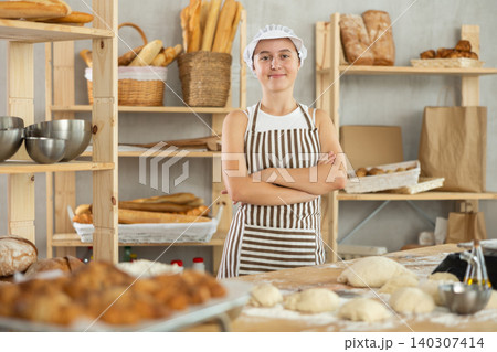 Teenage girl standing in bakehouse, ready to start baking Teenage girl standing in bakehouse, ready to start baking 140307414