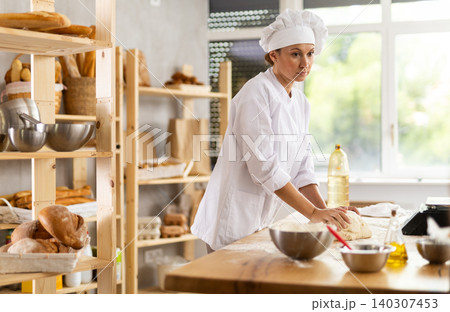 Professional baker kneading dough 140307453