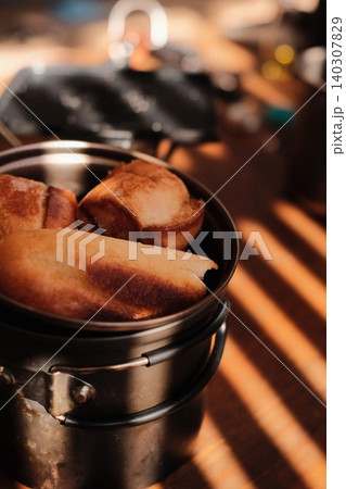 キャンプ用のクッカーに入れられた美味しそうな焼き立てのパン 140307829