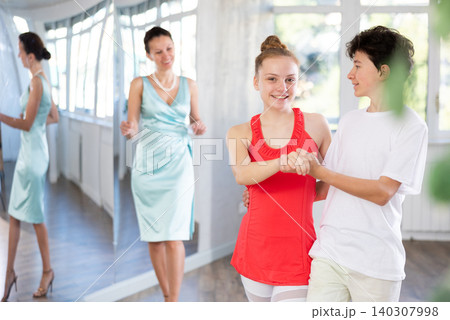 Teenage boy and girl performing waltz in pair during dance lesson Teenage boy and girl performing waltz in pair during dance lesson 140307998