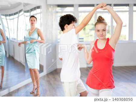 Motivated adolescent ballroom dancers practicing dance moves in studio 140308050
