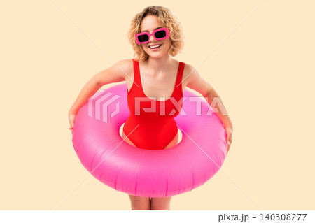 Woman poses confidently in pink float. Summer vibes and tropical glamour concept Woman poses confidently in pink float. Summer vibes and tropical glamour concept 140308277