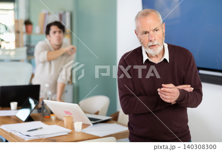 Outraged senior man turned his back on angry and shouting man boss. Outraged senior man turned his back on angry and shouting man boss. 140308300