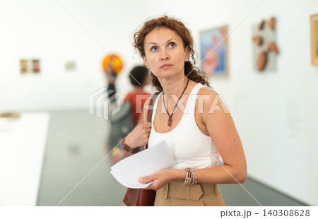 Woman captivated by abstract paintings at art museum Woman captivated by abstract paintings at art museum 140308628