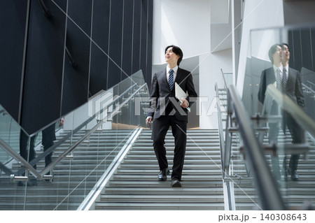 オフィスビルで若手新卒営業社員が目標と未来へ向かう歩く姿の成長と挑戦のキャリアビジネスイメージ 全身 オフィスビルで若手新卒営業社員が目標と未来へ向かう歩く姿の成長と挑戦のキャリアビジネスイメージ 全身 140308643