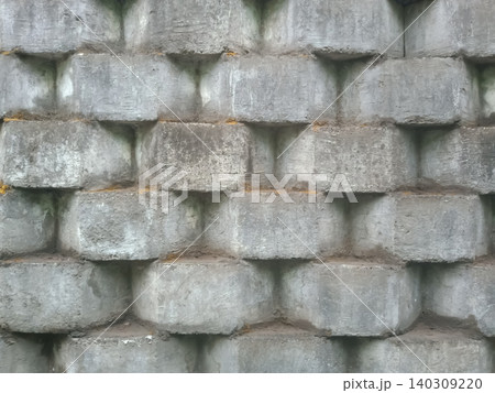 retaining wall made of interlocking, light grey concrete blocks. retaining wall made of interlocking, light grey concrete blocks. 140309220