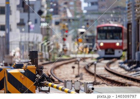 降りた踏切の遮断機とボケ味のある赤い電車の風景 降りた踏切の遮断機とボケ味のある赤い電車の風景 140309797