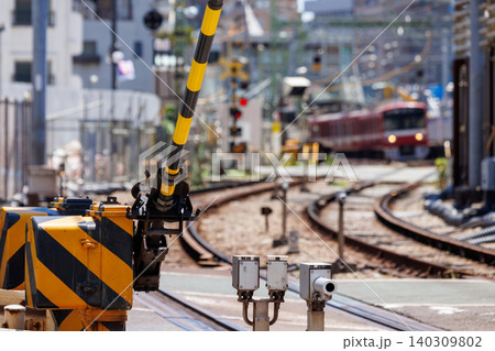 踏切の遮断機とボケ味のある赤い電車の風景 踏切の遮断機とボケ味のある赤い電車の風景 140309802