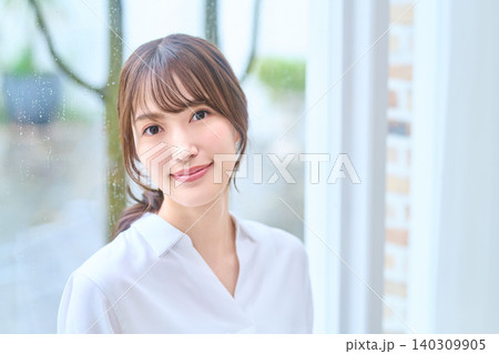 柔らかな笑顔の白シャツの女性ポートレート 140309905
