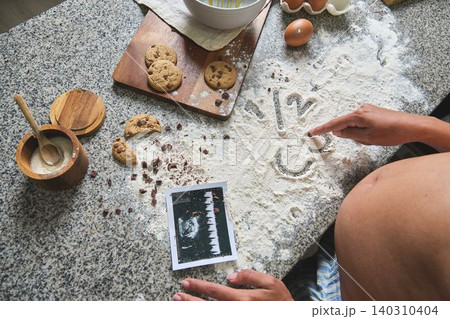 Pregnant woman baking cookies for baby future announcement Pregnant woman baking cookies for baby future announcement 140310404